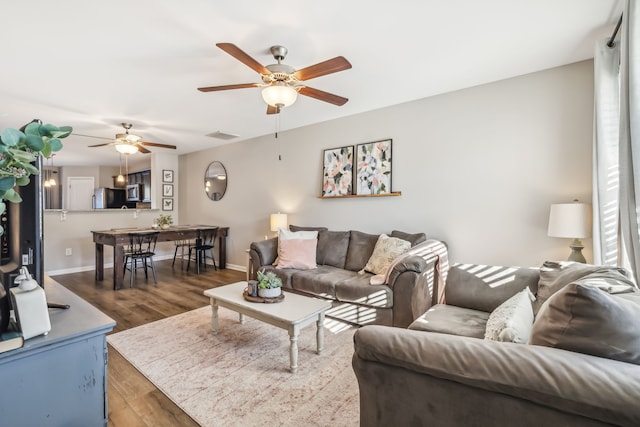 living room featuring hardwood / wood-style floors and ceiling fan