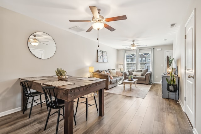 dining area with ceiling fan and dark hardwood / wood-style flooring