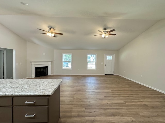 unfurnished living room featuring ceiling fan, lofted ceiling, and hardwood / wood-style floors