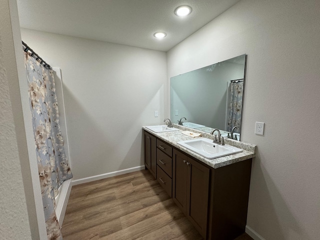 bathroom with wood-type flooring, vanity, and walk in shower