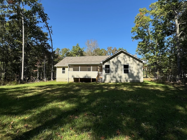 rear view of house featuring a yard