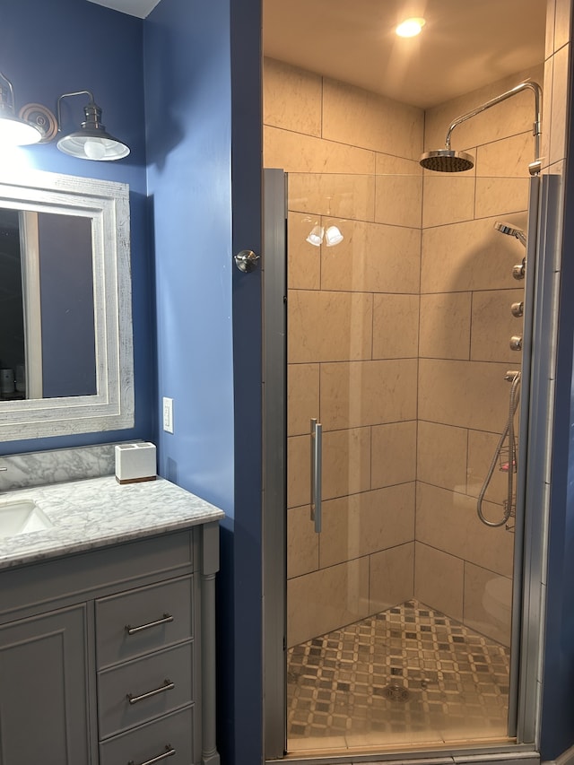 bathroom featuring a shower with shower door and vanity