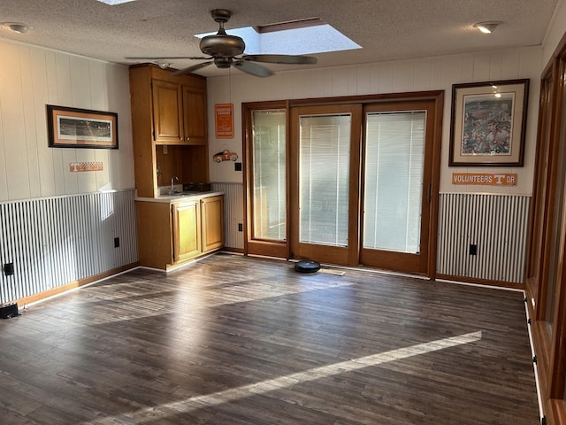 841 Asbury Dr, New Johnsonville, TN 37134 - unfurnished dining area featuring a textured ceiling, ceiling fan, a skylight, dark wood-style flooring, and wood walls