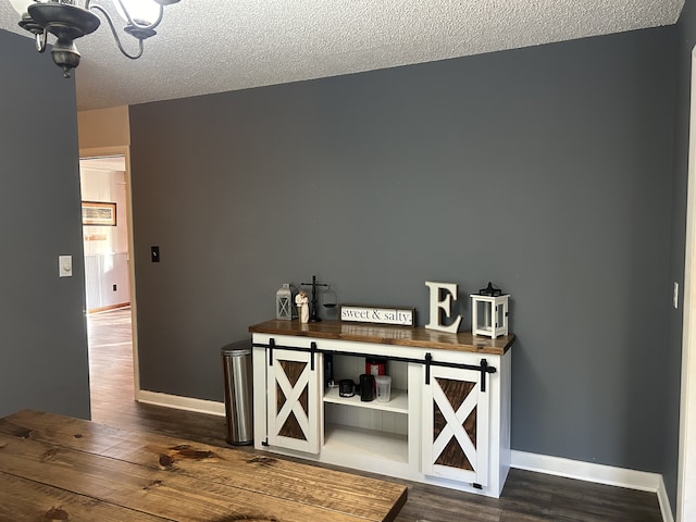 interior space featuring a barn door, dark hardwood / wood-style floors, and a textured ceiling