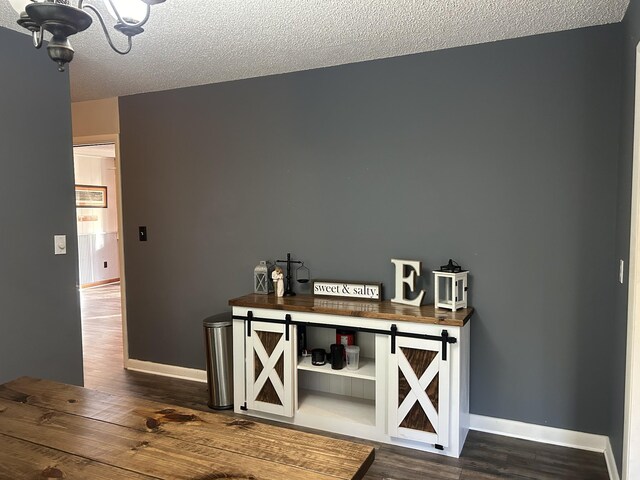 841 Asbury Dr, New Johnsonville, TN 37134 - bar area with wood finished floors, baseboards, a chandelier, and a textured ceiling