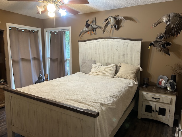 bedroom featuring dark hardwood / wood-style flooring, ceiling fan, and a textured ceiling