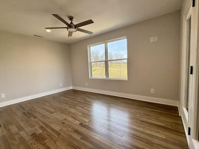 spare room featuring ceiling fan and dark wood-type flooring