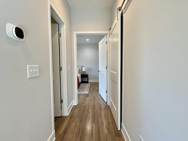 hall with hardwood / wood-style floors and a barn door