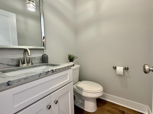 bathroom featuring toilet, vanity, and hardwood / wood-style floors