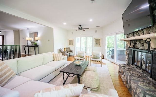 living room with a fireplace, light hardwood / wood-style floors, and ceiling fan