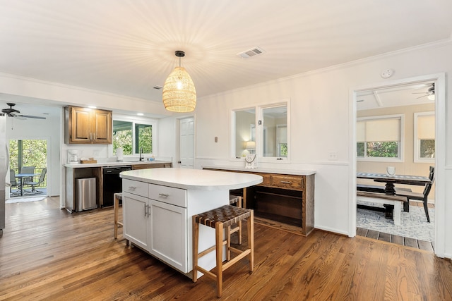 kitchen with pendant lighting, black dishwasher, a kitchen island, dark hardwood / wood-style flooring, and a breakfast bar