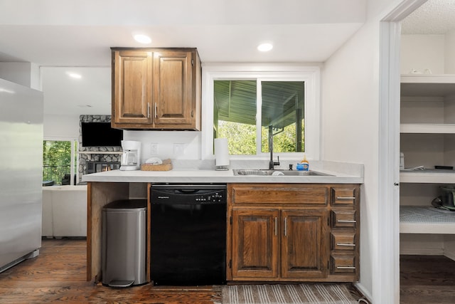 kitchen featuring stainless steel fridge, dark wood-type flooring, black dishwasher, and sink