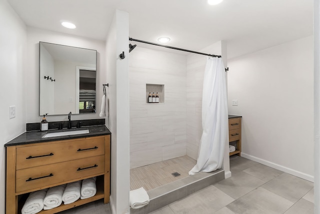 bathroom featuring tile patterned floors, vanity, and curtained shower