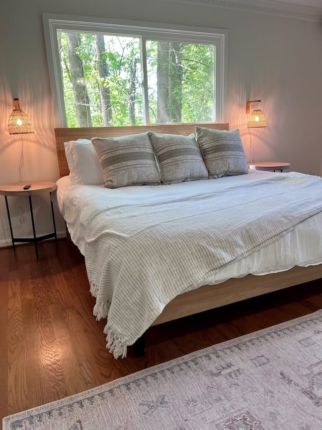 bedroom with wood-type flooring and multiple windows