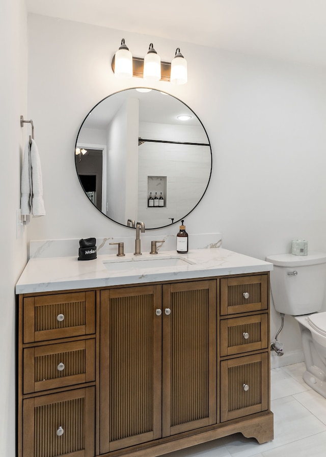 bathroom featuring vanity, tile patterned flooring, and toilet