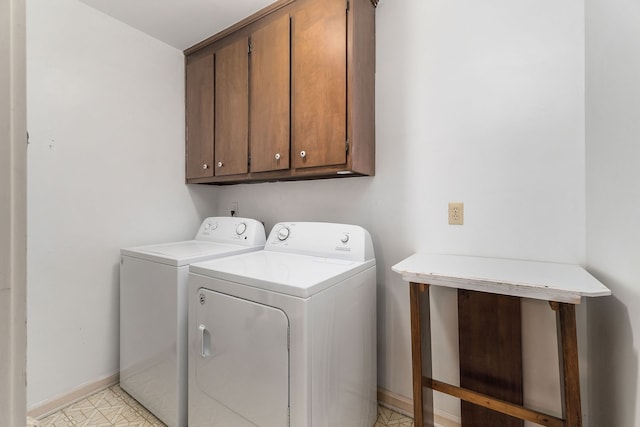 clothes washing area with washer and clothes dryer and cabinets