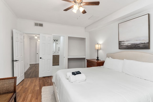 bedroom with ornamental molding, connected bathroom, light wood-type flooring, and ceiling fan