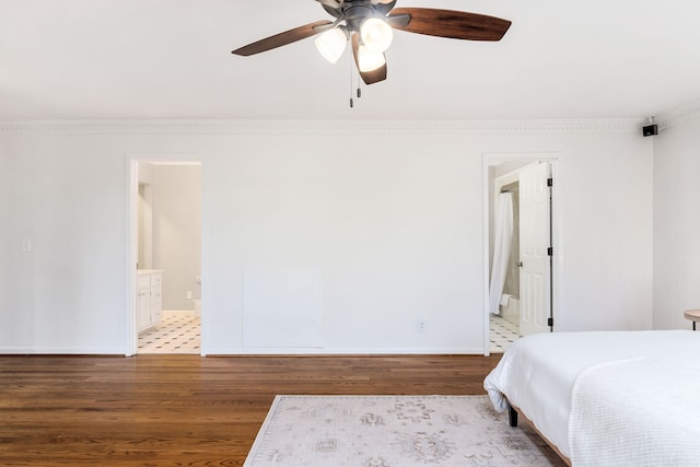 unfurnished bedroom with ceiling fan, ornamental molding, hardwood / wood-style floors, and ensuite bathroom