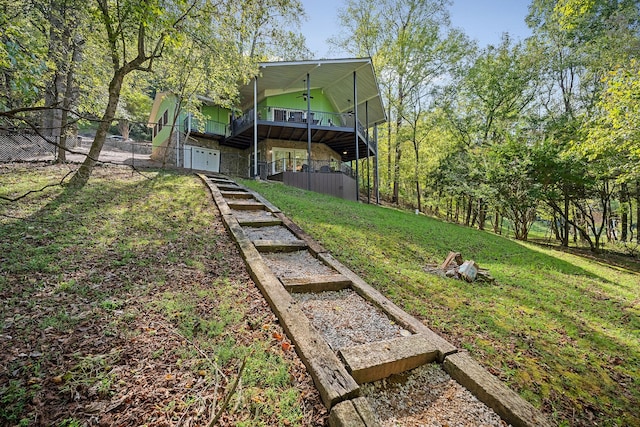 view of yard with ceiling fan and a deck