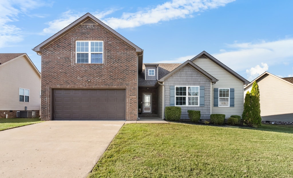 front facade with a front yard, a garage, and central AC unit