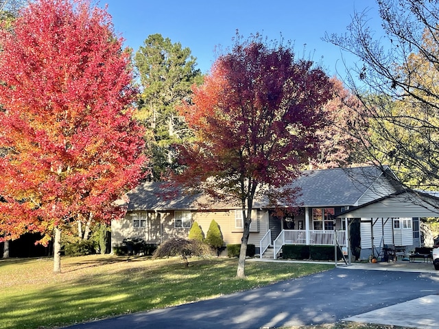 view of front facade featuring a front yard, a porch, and a carport