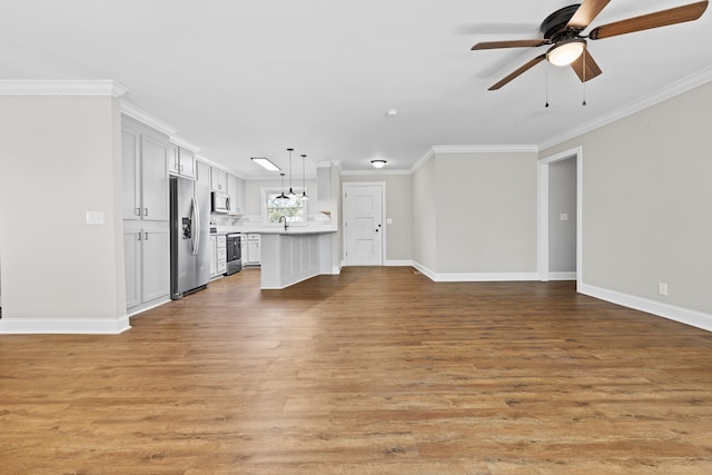 unfurnished living room featuring ornamental molding, ceiling fan, sink, and light hardwood / wood-style flooring