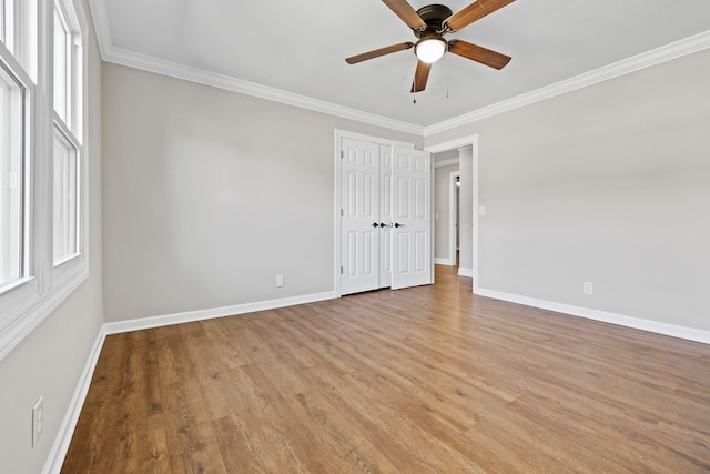 empty room with plenty of natural light, ornamental molding, and light hardwood / wood-style flooring