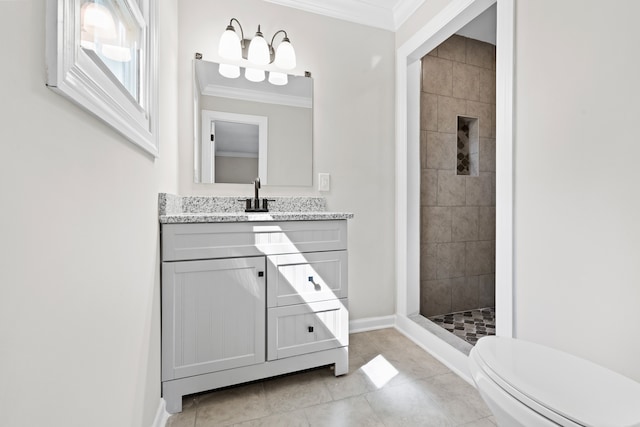 bathroom featuring vanity, tile patterned floors, tiled shower, ornamental molding, and toilet