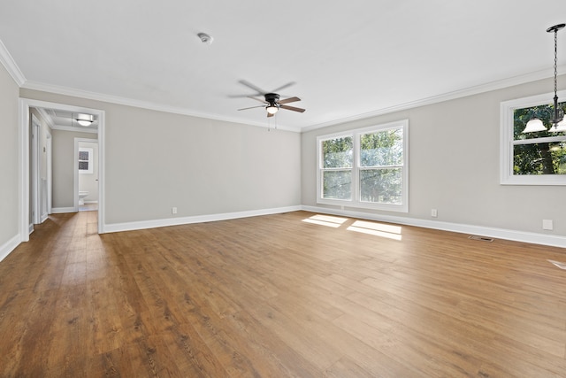 spare room with hardwood / wood-style flooring, ceiling fan with notable chandelier, and ornamental molding