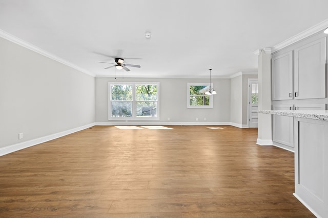 unfurnished living room with ceiling fan with notable chandelier, ornamental molding, and light wood-type flooring