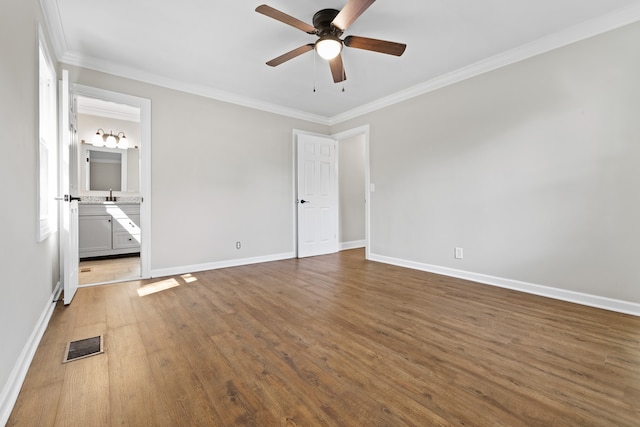 unfurnished bedroom featuring ornamental molding, ensuite bathroom, ceiling fan, and dark wood-type flooring