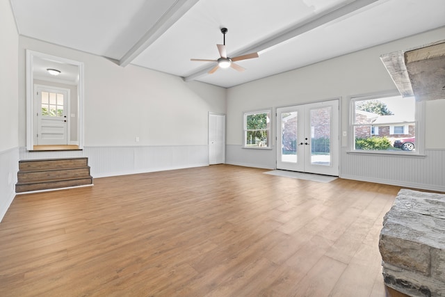 unfurnished living room with french doors, light hardwood / wood-style floors, beam ceiling, and ceiling fan