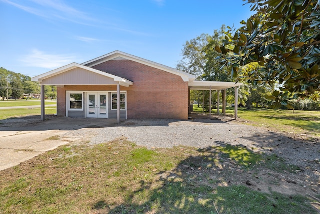 exterior space featuring a carport, french doors, and a front yard