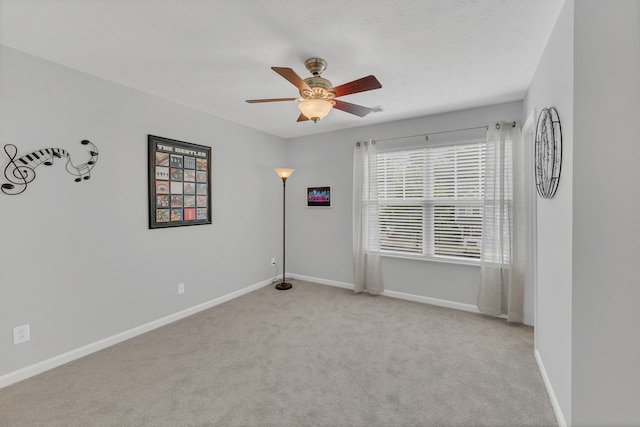 unfurnished room featuring a textured ceiling, ceiling fan, and light colored carpet