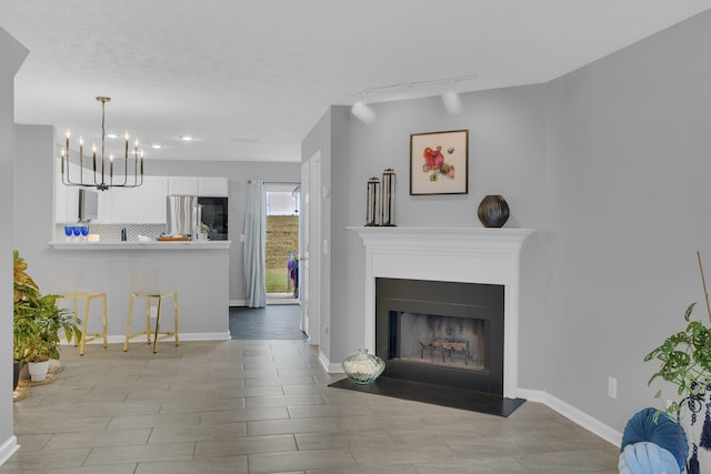 living room with rail lighting and an inviting chandelier