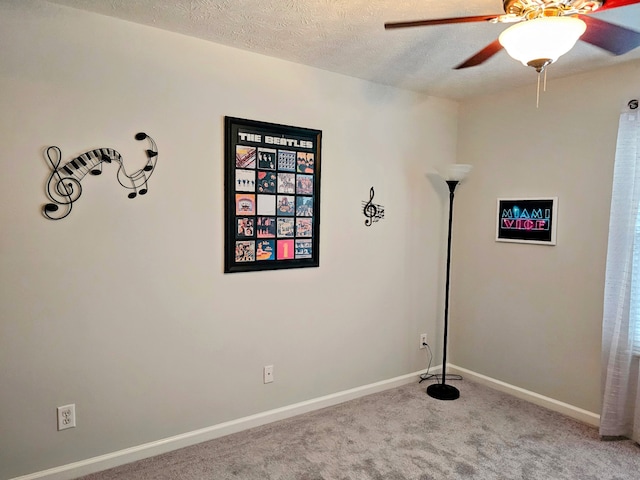 unfurnished room with ceiling fan, a textured ceiling, and carpet