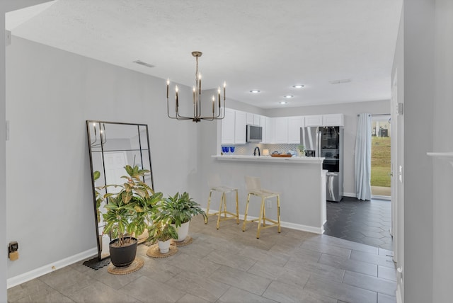 dining area featuring an inviting chandelier and a textured ceiling