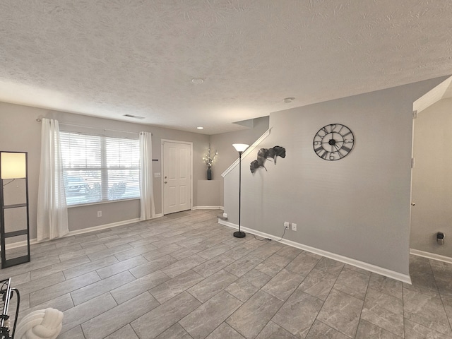 unfurnished room with a textured ceiling