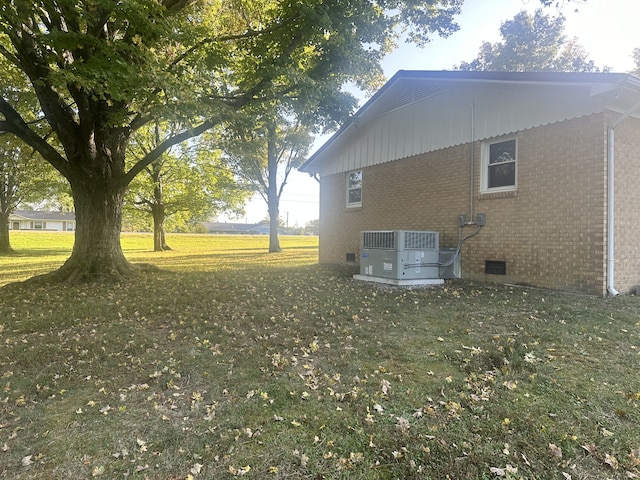 view of home's exterior featuring a yard and central AC