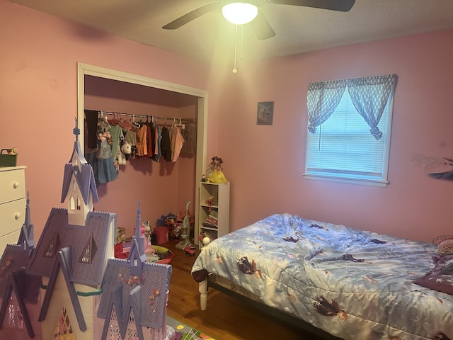 bedroom with hardwood / wood-style flooring, ceiling fan, and a closet