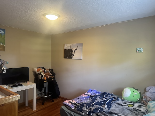 bedroom featuring a textured ceiling and hardwood / wood-style flooring