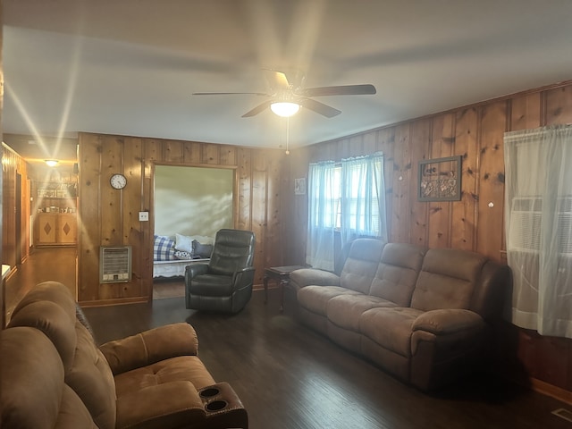 living room featuring ceiling fan, wood walls, and heating unit