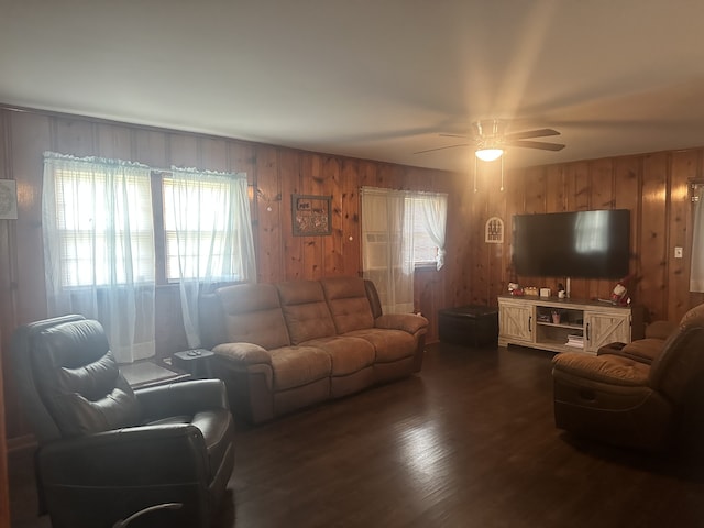 living room featuring ceiling fan, wood walls, and dark hardwood / wood-style floors