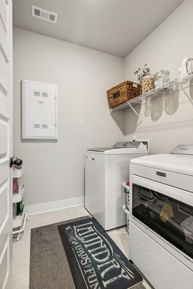 clothes washing area with independent washer and dryer and light tile patterned floors