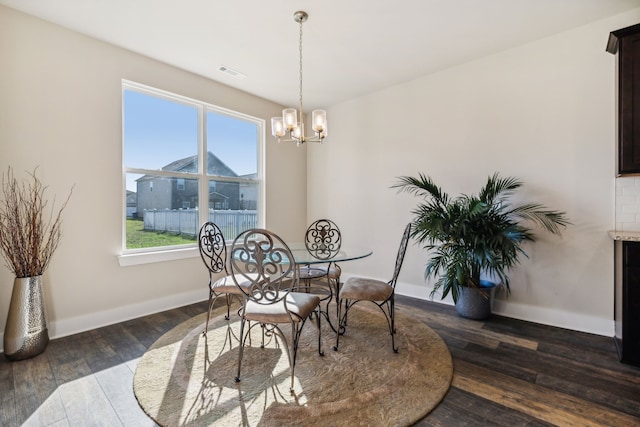 dining room featuring an inviting chandelier and dark hardwood / wood-style flooring