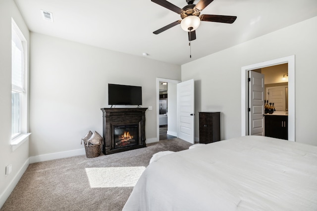 bedroom with ensuite bath, carpet flooring, and ceiling fan