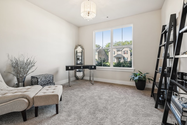 sitting room featuring carpet floors and an inviting chandelier