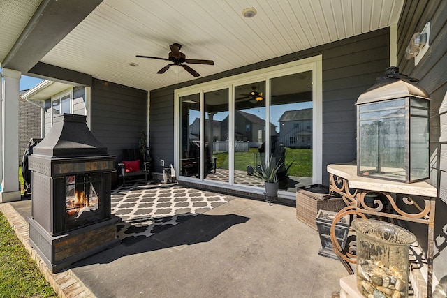 view of patio featuring an outdoor fireplace and ceiling fan