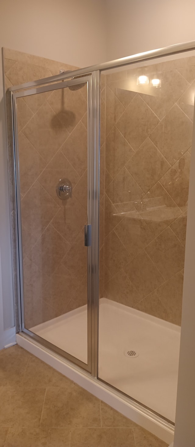 bathroom with walk in shower and tile patterned flooring