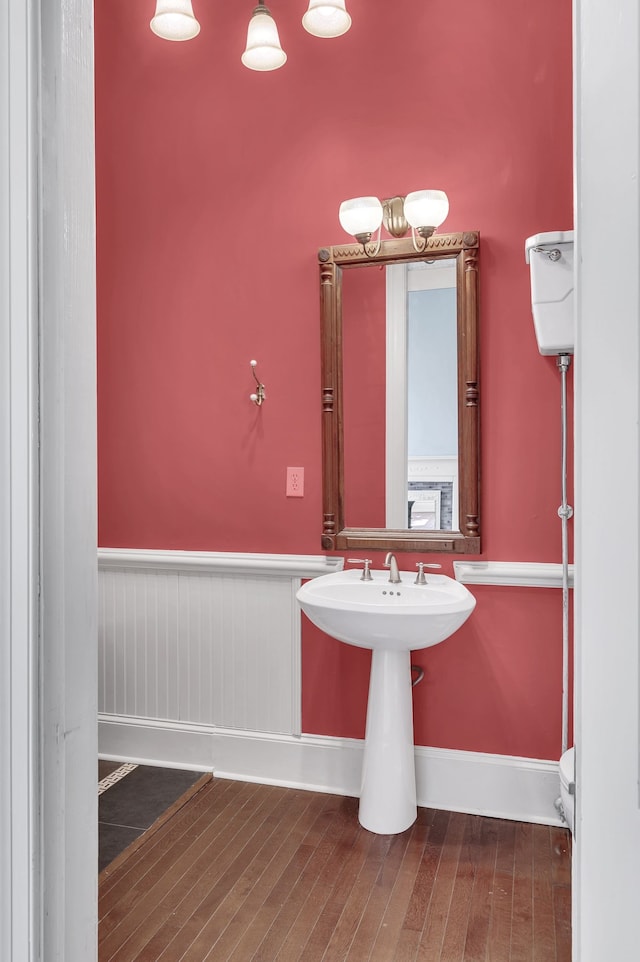 bathroom featuring wood-type flooring and toilet